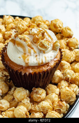 Salted Caramel Cupcake on Caramel Popcorn - Light Background Stock Photo