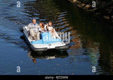 Malmo, Sweden - August 23, 2017: One adult and two kids in a blue and white pedalo. Stock Photo
