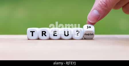 Hand turns a dice and changes the German word 'nein' to 'ja' ('no' to 'yes' in English). Stock Photo