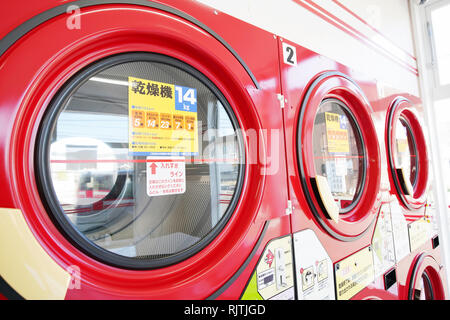 Row of industrial laundry machines in a public laundromat Stock Photo