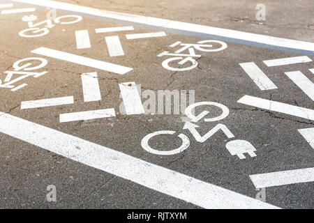 Asphalt road with bicycle and electric transport lane. Cycle and zero emission vehicles white sign on floor. Recreation area for green energy