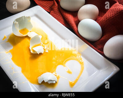 Broken Fresh Matrimony Egg on White Plate Stock Photo