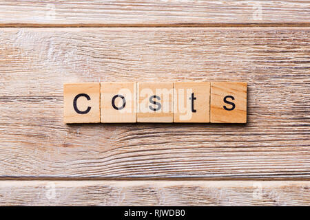 costs word written on wood block. costs text on wooden table for your desing, concept. Stock Photo