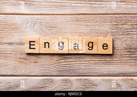 ENGAGE word written on wood block. ENGAGE text on wooden table for your desing, concept. Stock Photo