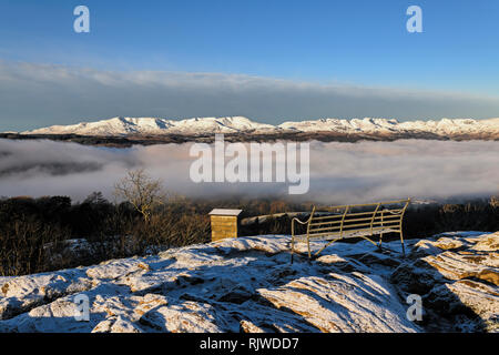 Far-reaching views above the cloud inversion of the snow covered fells from Orrest Head, Windermere, on a cold, crisp winter's morning Stock Photo