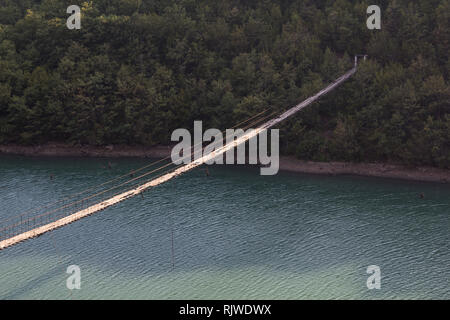 Albania: Decaying Hanging or suspension bridge with loose wires	 and broken wooden planks Stock Photo
