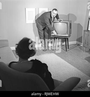Television in the 1950s. A proud elderly man is pictured in his home with his wife with the latest in electronic home equipment visible. A typical television set on thin legs.  Photo Kristoffersson ref CD89-9. Sweden 1959 Stock Photo