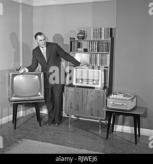 Television in the 1950s. A proud elderly man is pictured in his home with the latest in electronic home equipment. A typical television set on thin legs, a radio and a tape recorder.  Photo Kristoffersson ref CD88-10. Sweden 1959 Stock Photo