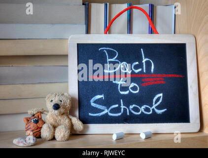 'Back to School' phrase wrongly written on a wooden chalkboard using white chalk. Stock Photo