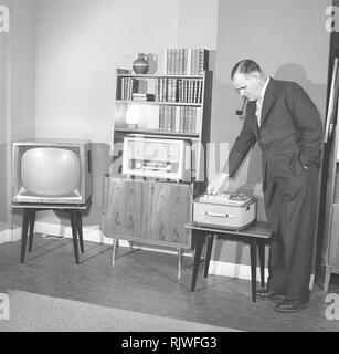 Television in the 1950s. A proud elderly man is pictured in his home with the latest in electronic home equipment. A typical television set on thin legs, a radio and a tape recorder.  Photo Kristoffersson ref CD91-4. Sweden 1959 Stock Photo