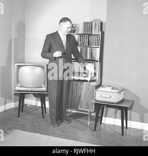 Television in the 1950s. A proud elderly man is pictured in his home with the latest in electronic home equipment. A typical television set on thin legs, a radio and a tape recorder.  Photo Kristoffersson ref CD91-7. Sweden 1959 Stock Photo