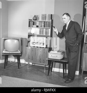 Television in the 1950s. A proud elderly man is pictured in his home with the latest in electronic home equipment. A typical television set on thin legs, a radio and a tape recorder.  Photo Kristoffersson ref CD91-9. Sweden 1959 Stock Photo