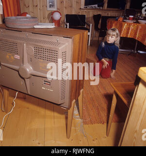 Television in the 1960s. A girl is sitting in front of a television set with her eyes on the screen and the program. Sweden 1969 Stock Photo