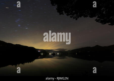 Star trails over Derwentwater, Keswick town, Lake District National Park, Cumbria County, England. Stock Photo