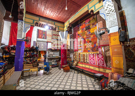 Inside interior of Carpet shop with colourful moroccan rugs and berber carpets on display in a souk market in medina. Fes El Bali, Fez, Morocco