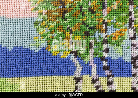 Tapestry texture background with blue, green, pink and yellow woven thread - hand made Stock Photo