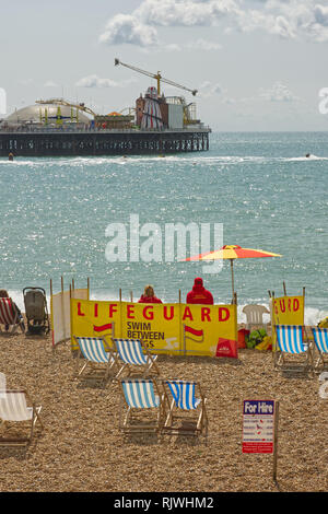 Lifeguards on the beach at Brighton in East Sussex, England. With pier in background. Stock Photo