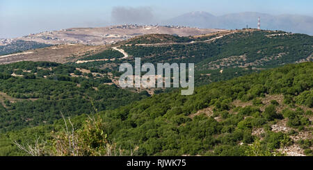 panorama of the Israel Lebanon border in the upper galillee and golan heights with mt hermon and a hazy smokey sky in the background Stock Photo