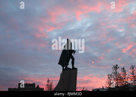 Vor der Hallgrimskirkja steht die Statue von Leif Eriksson.Hier mit der Streitaxt vor rotem abendhimmel Stock Photo
