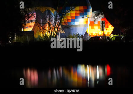 Hot air balloons participate in a night glow, where pilots light up the balloon using liquid propane with an open flame. Stock Photo