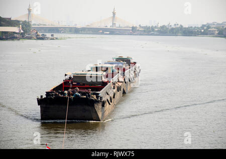 Asian thai people sailing barge and tugboat cargo ship in Chao Phraya or chaopraya river from Bangkok go to Ayutthaya at Phra Nang Klao bridge in Nont Stock Photo