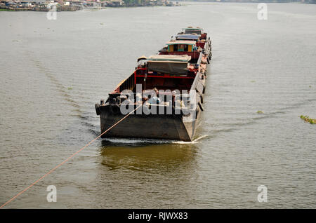 Asian thai people sailing barge and tugboat cargo ship in Chao Phraya or chaopraya river from Bangkok go to Ayutthaya at Phra Nang Klao bridge in Nont Stock Photo