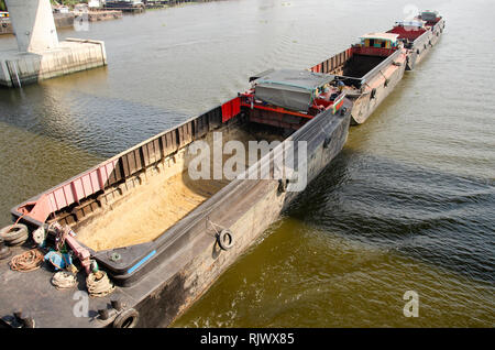 Asian thai people sailing barge and tugboat cargo ship in Chao Phraya or chaopraya river from Bangkok go to Ayutthaya at Phra Nang Klao bridge in Nont Stock Photo