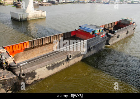 Asian thai people sailing barge and tugboat cargo ship in Chao Phraya or chaopraya river from Bangkok go to Ayutthaya at Phra Nang Klao bridge in Nont Stock Photo