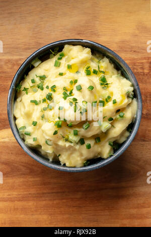 Pomme puree, an overhead photo of a bowl of potato puree with herbs, shot from the top on a rustic background with a place for text Stock Photo