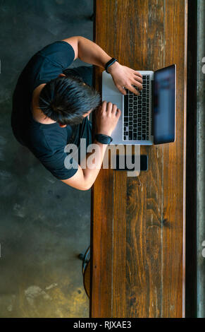 Top view of Asian man working on laptop Stock Photo
