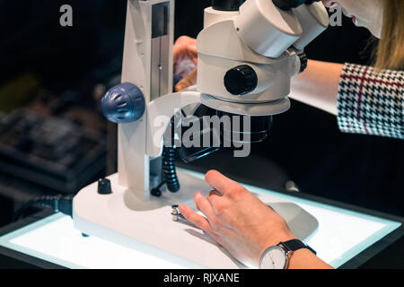young female scientist looking through a microscope in a laboratory Stock Photo