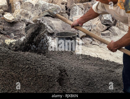 Man working outside with a shovel. Construction, cement, rocks and concrete Stock Photo