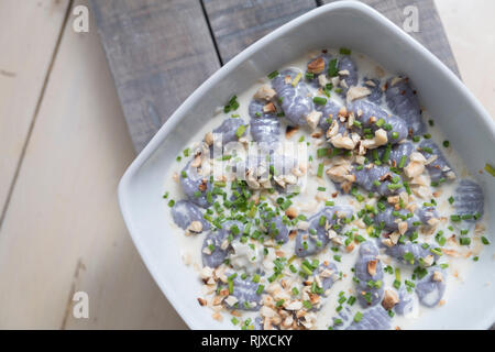 top view of  a gnocchi viola. Violet italian gnocchi made with violet potatoes and fonduta of gorgonzola cheese, mascarpone. grains of hazelnuts and c Stock Photo