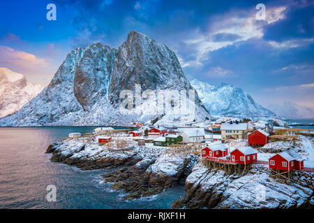 Famous tourist attraction Hamnoy fishing village on Lofoten Islands, Norway with red rorbu houses. With falling snow in winter on sunrise Stock Photo