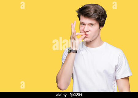 Young handsome man wearing casual white t-shirt over isolated background mouth and lips shut as zip with fingers. Secret and silent, taboo talking Stock Photo