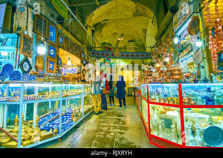 ISFAHAN, IRAN - OCTOBER 19, 2017: The stalls in Grand Bazaar offer variety of handimade souvenirs, copper dishes, pottery and wooden furniture, on Oct Stock Photo