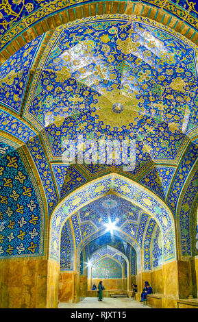 ISFAHAN, IRAN - OCTOBER 19, 2017: The large arched corridor with tile decorations of Shah Mosque, on October 19 in Isfahan Stock Photo