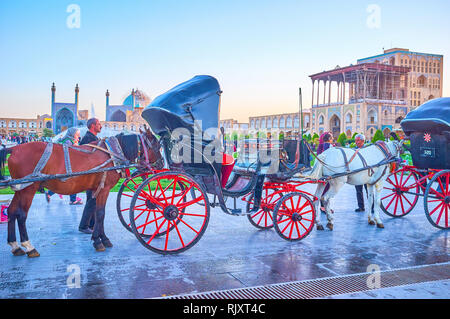 ISFAHAN, IRAN - OCTOBER 19, 2017: One of the most unusual attractions in Naqsh-e Jahan Square is a riding in traditional horse drawn carriage around t Stock Photo