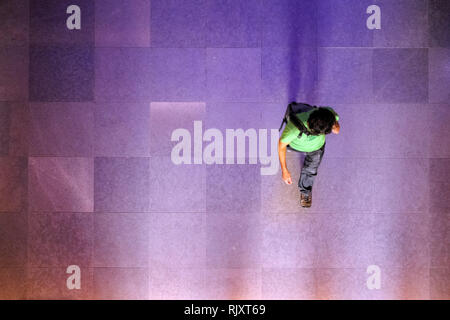 Looking down at silhouette of business man, traveler walking on the marble brick floor. Top view, space for type Stock Photo