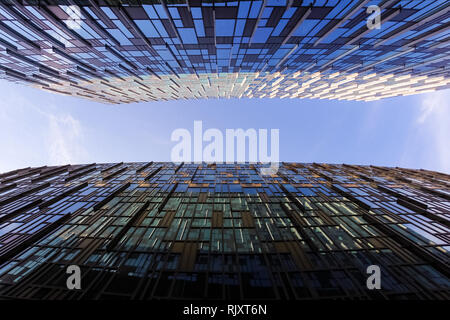 Looking up between two modern business skyscrapers, high-rise buildings, architecture raising to the sky, sun. Concepts of financial, economics Stock Photo