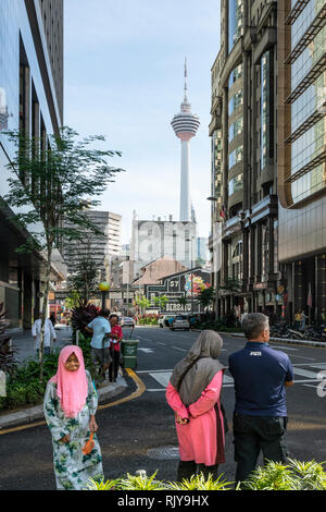 People on the streets with the Menara tower in the background in Kuala Lumpur, Malaysia Stock Photo