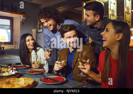 Happy friends talk in a restaurant in the evening.  Stock Photo