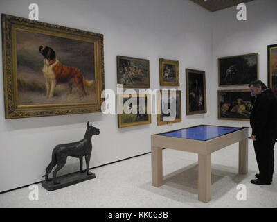 08 February 2019, US, New York: A visitor stands in front of works of art in the 'Museum of the Dog'. New York has recently opened its own museum again with the theme of dogs. The museum is run by the American Kennel Club (AKC) and has one of the largest collections of dog art in the world. Photo: Johannes Schmitt-Tegge/dpa Stock Photo