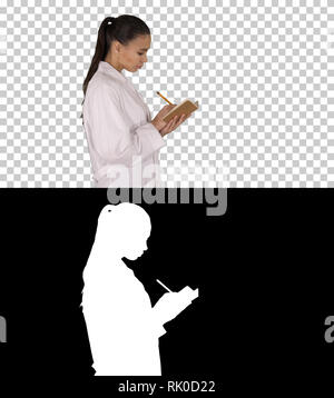 On Alpha Matte. Medium shot. Side view. Successful medical doctors making notes while walking, Alpha Channel. Professional shot in 4K resolution. 013. Stock Photo