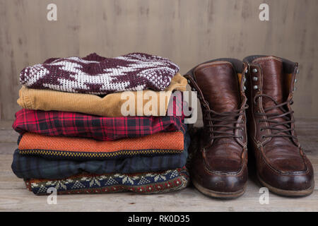 Pile of knitted winter sweaters on wooden background Stock Photo