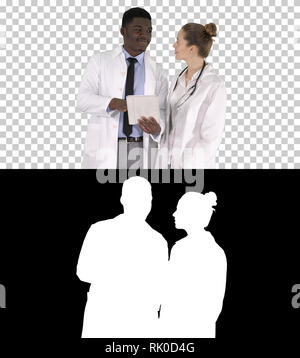 On Alpha Matte. Medium shot. Intellectual healthcare professional afro american doctor with collegue using digital tablet, Alpha Channel Professional  Stock Photo