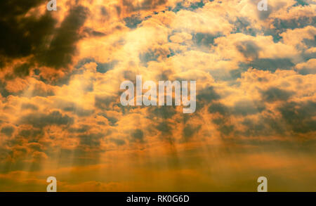 God light. Dramatic dark cloudy sky with sun beam. Yellow sun rays through dark and white clouds. God light from heaven for hope and faithful concept. Stock Photo