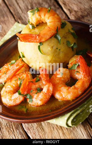 Delicious latino American Mofongo from bananas and chicharron served with shrimp and broth close-up on a plate on the table. vertical Stock Photo