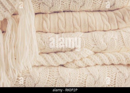 White knits pile. Warm cozy home concept. Horizontal, warm toning Stock Photo