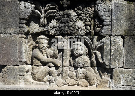 Closeup wall ornamented with bas-reliefs religion scene. Highly detailed stone carving. Borobudur Buddhist temple, Magelang, Indonesia Stock Photo